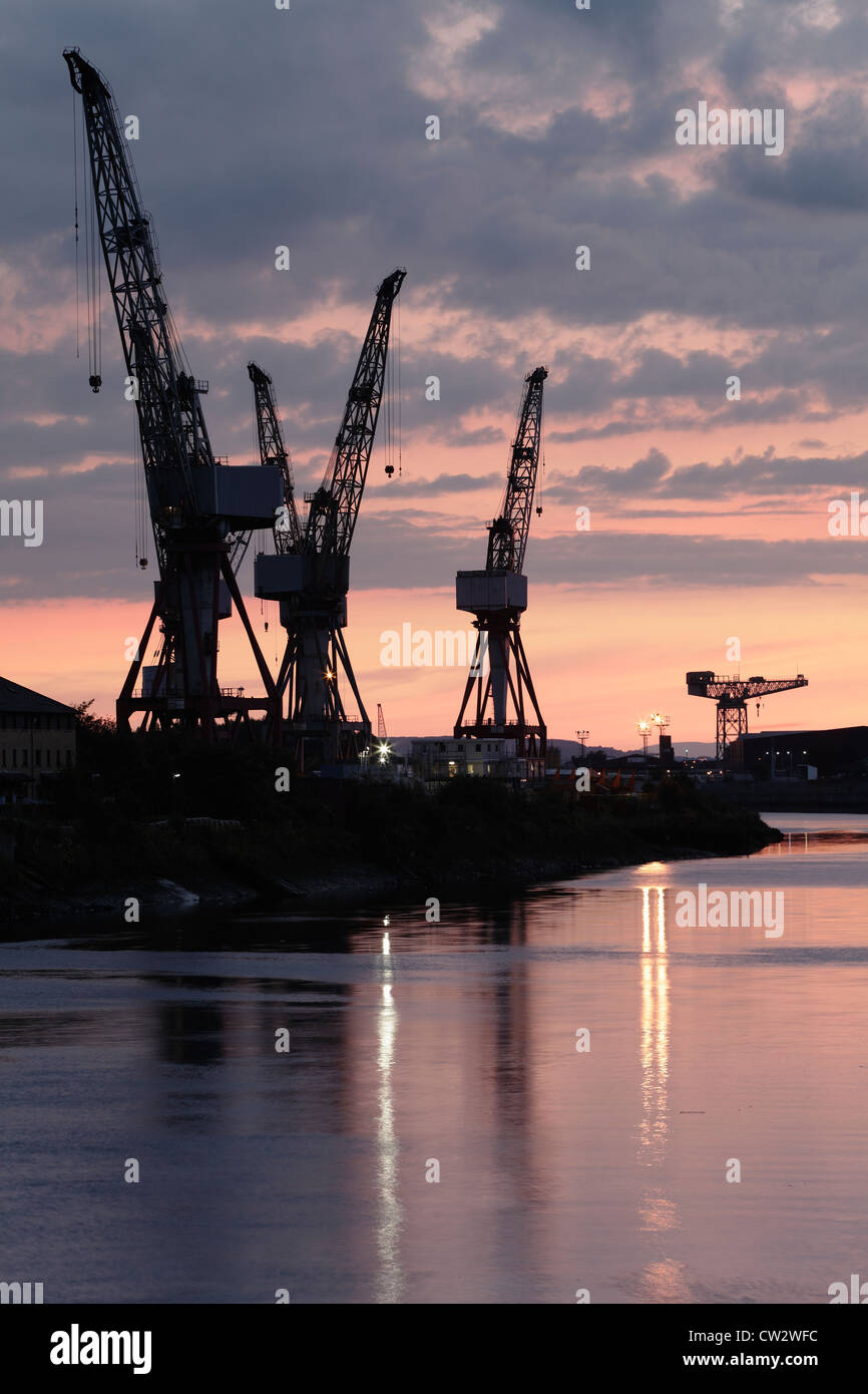 Coucher de soleil sur les grues de chantier naval à BAE Systems à côté de la rivière Clyde à Govan, Glasgow, Écosse, Royaume-Uni Banque D'Images