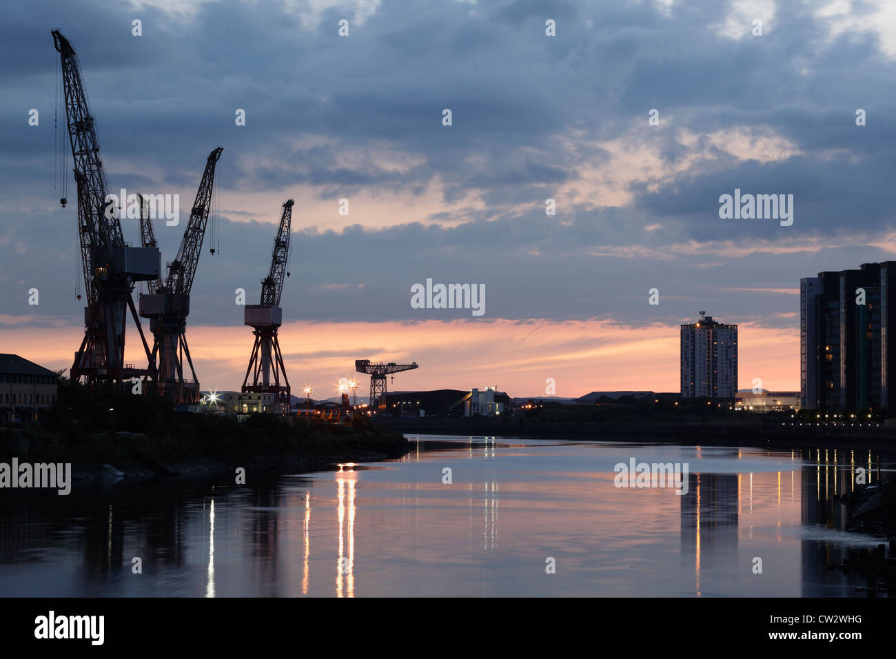 Coucher de soleil sur les grues de chantier naval à BAE Systems à côté de la rivière Clyde à Govan, Glasgow, Écosse, Royaume-Uni Banque D'Images