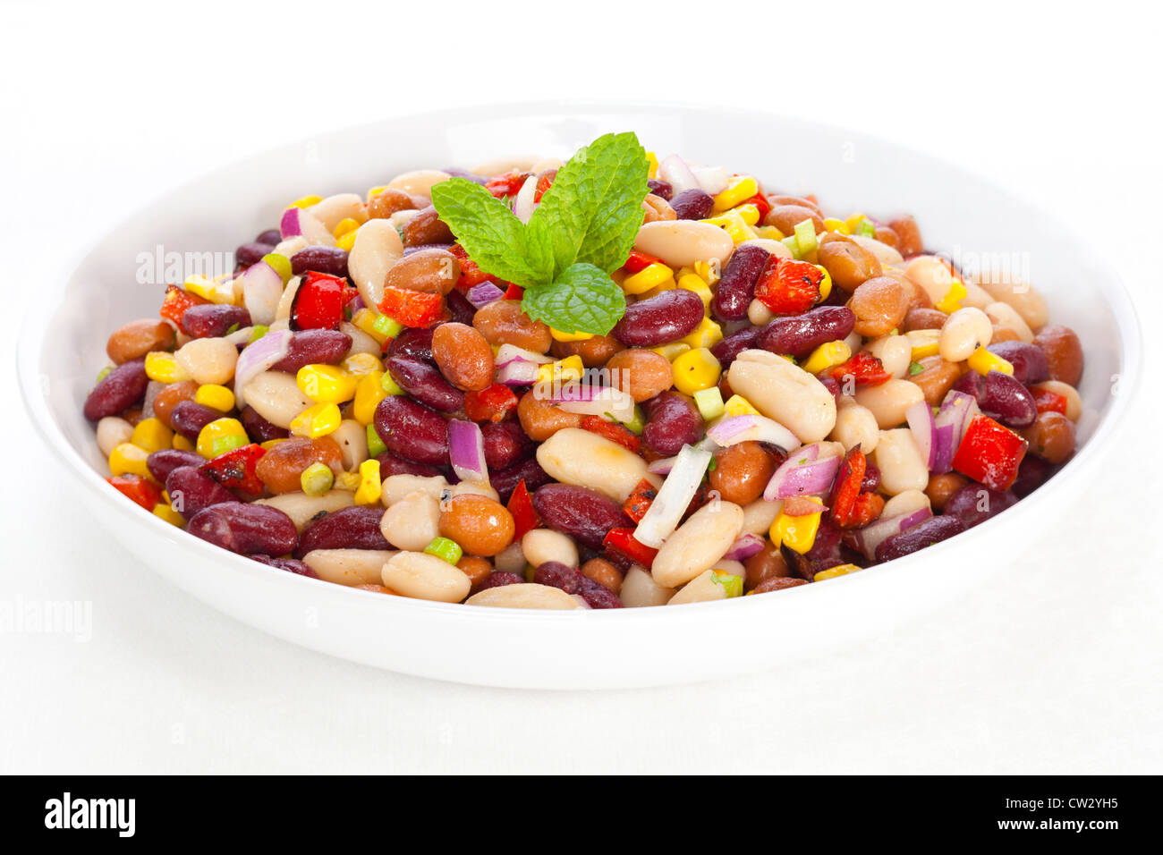 Salade de haricots avec trois maïs, poivrons rouges et oignons rouges dans une vinaigrette dresing. Banque D'Images