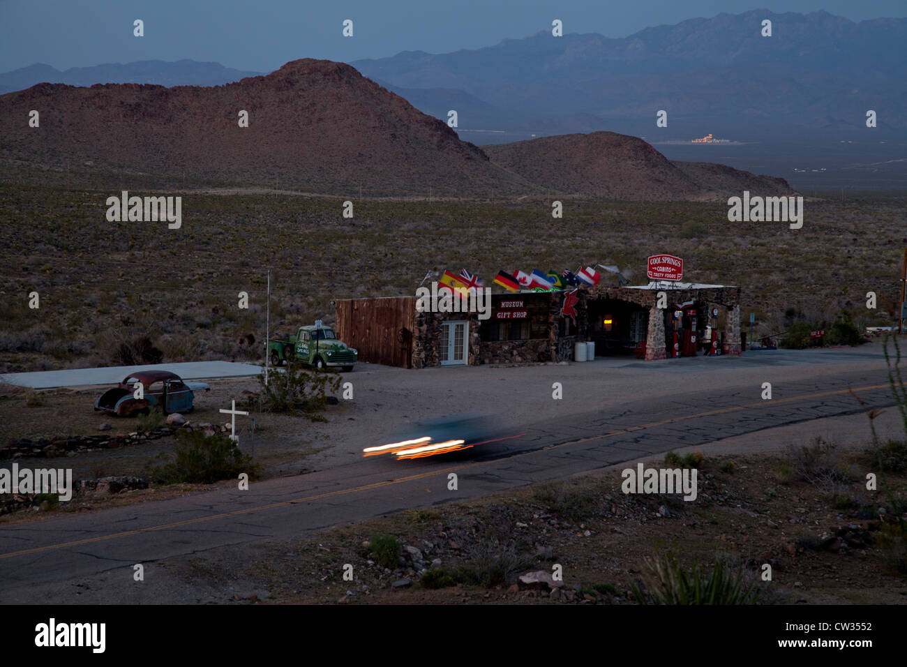 Comme la nuit tombe d'une voiture conduit le passé restauré Cool Springs station le long de la Route 66 dans l'ouest de l'Arizona. Banque D'Images