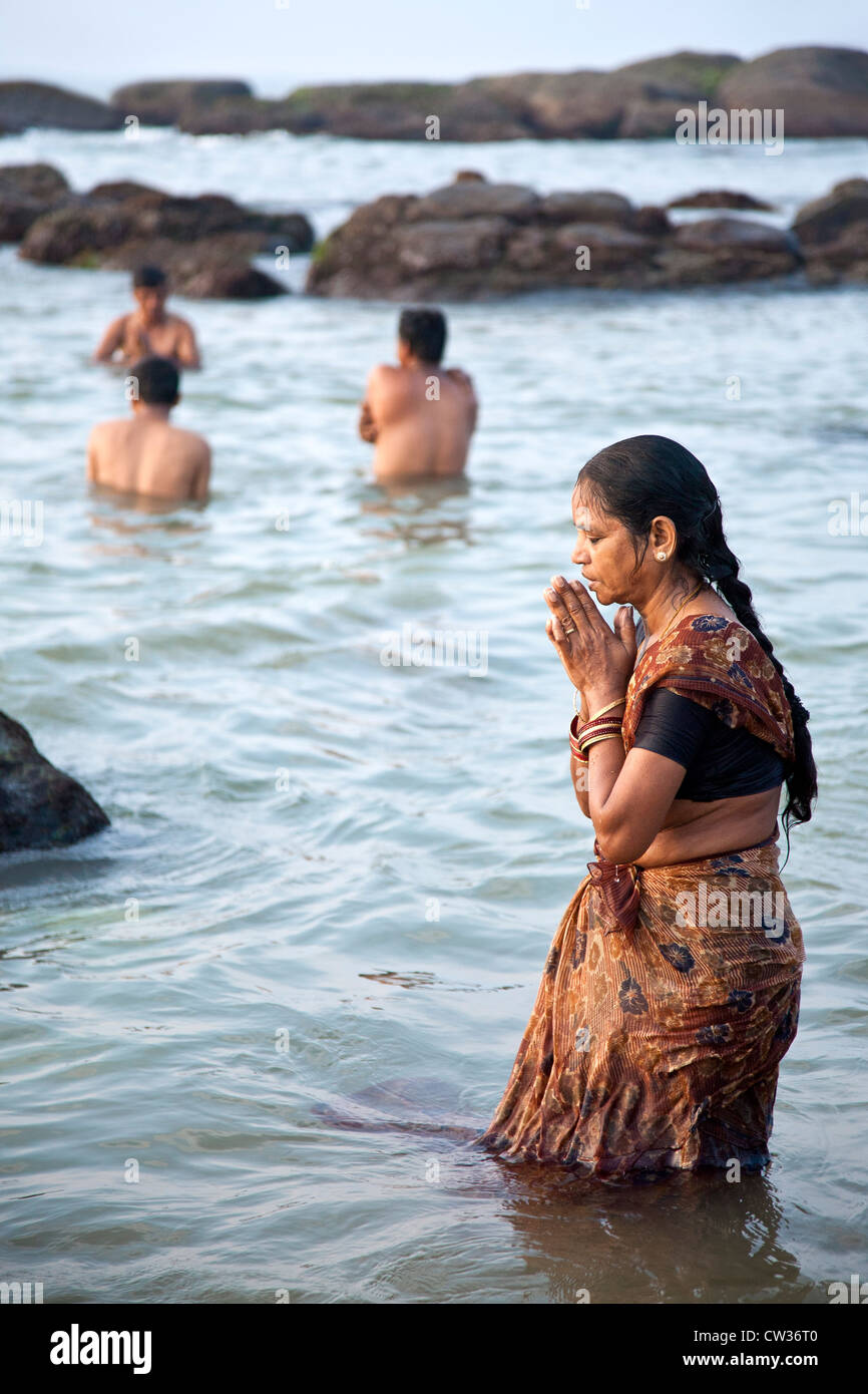 Femme en prière dans la mer. Kanyakumari. Tamil Nadu. L'Inde Banque D'Images