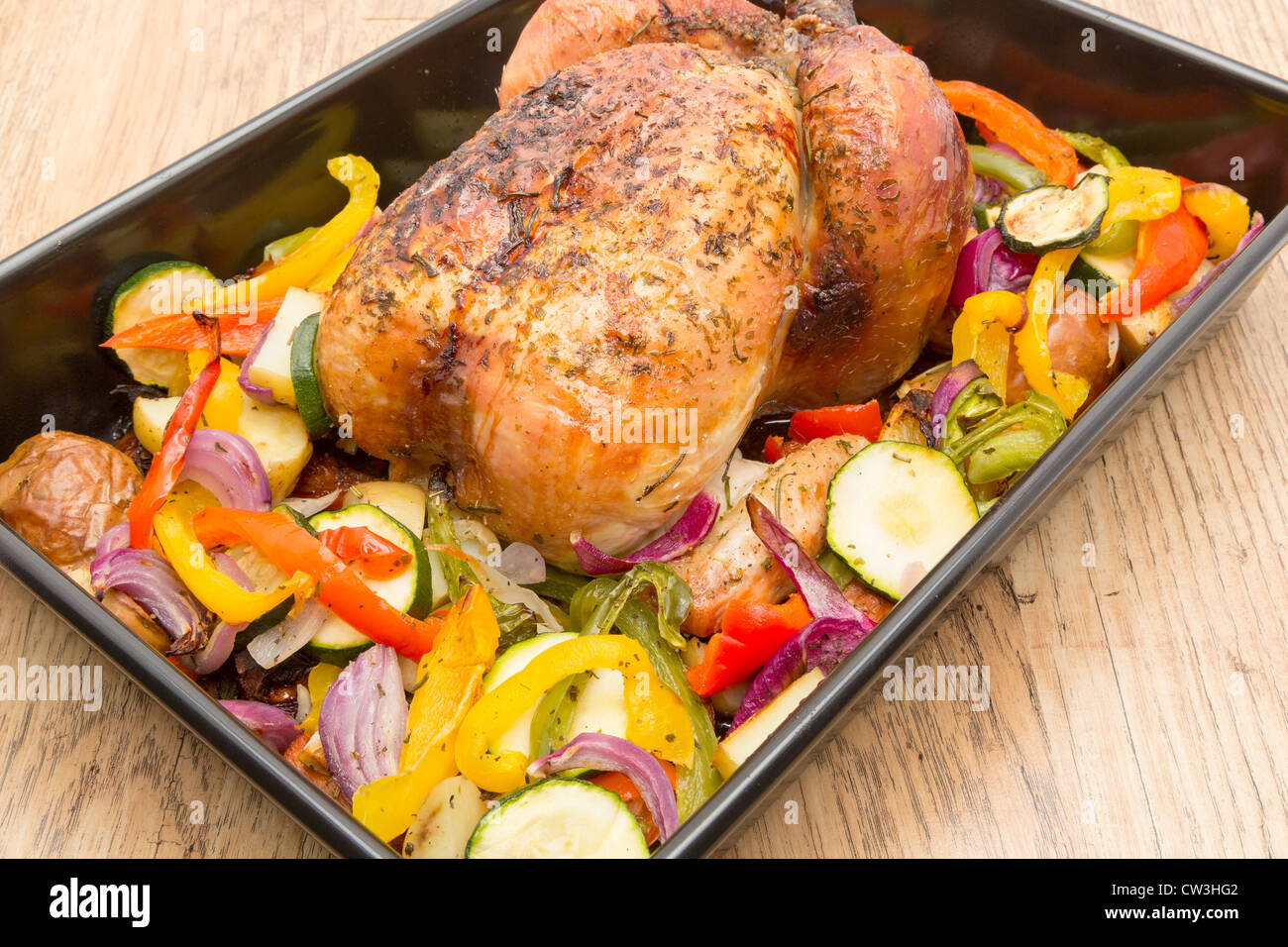 Un prêt à manger des ailes de poulet dans un plat allant au four avec des légumes grillés - studio shot Banque D'Images