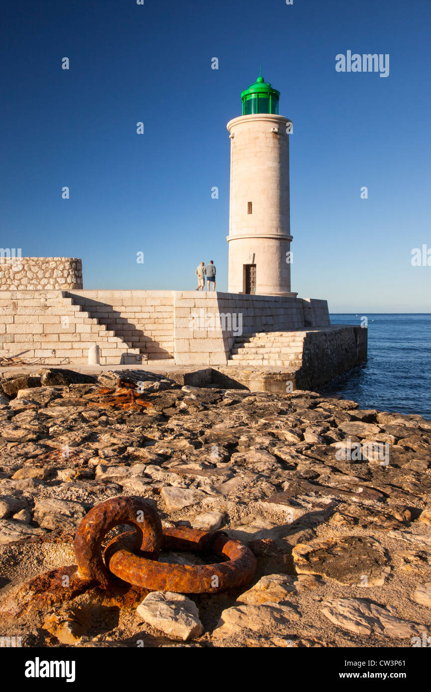 Deux hommes marcher sous le phare de Cassis à l'entrée du port de Cassis, Provence, France Banque D'Images