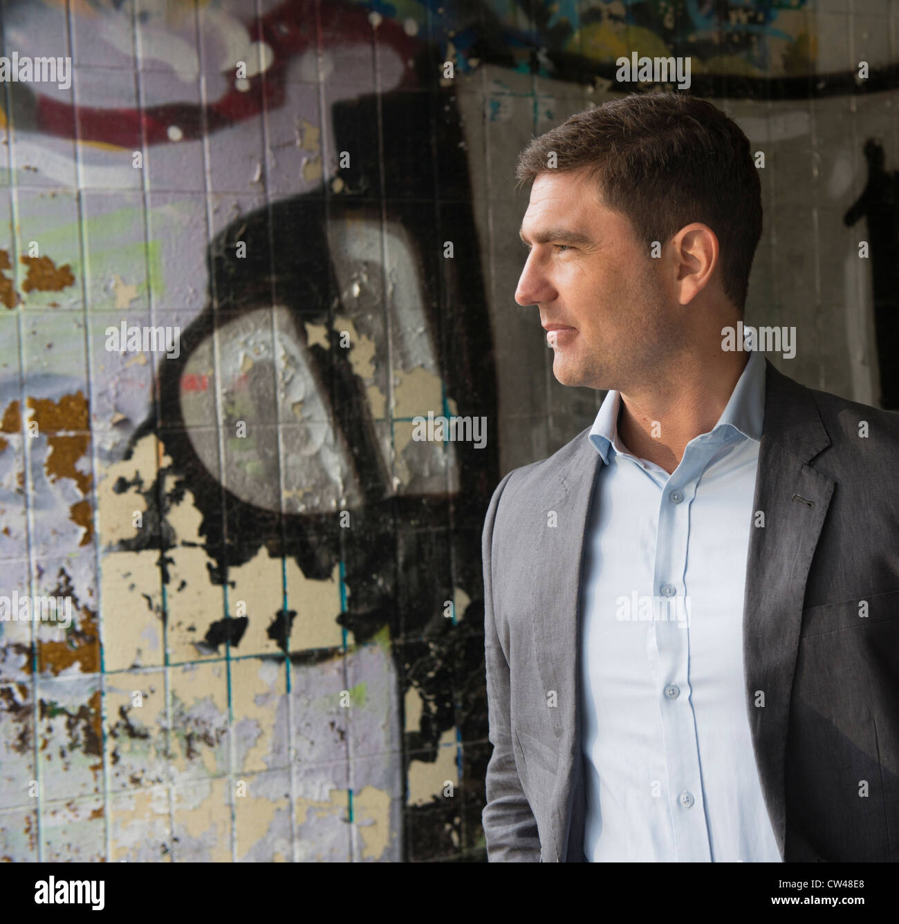 Homme debout en passage sous couvert de graffiti Banque D'Images