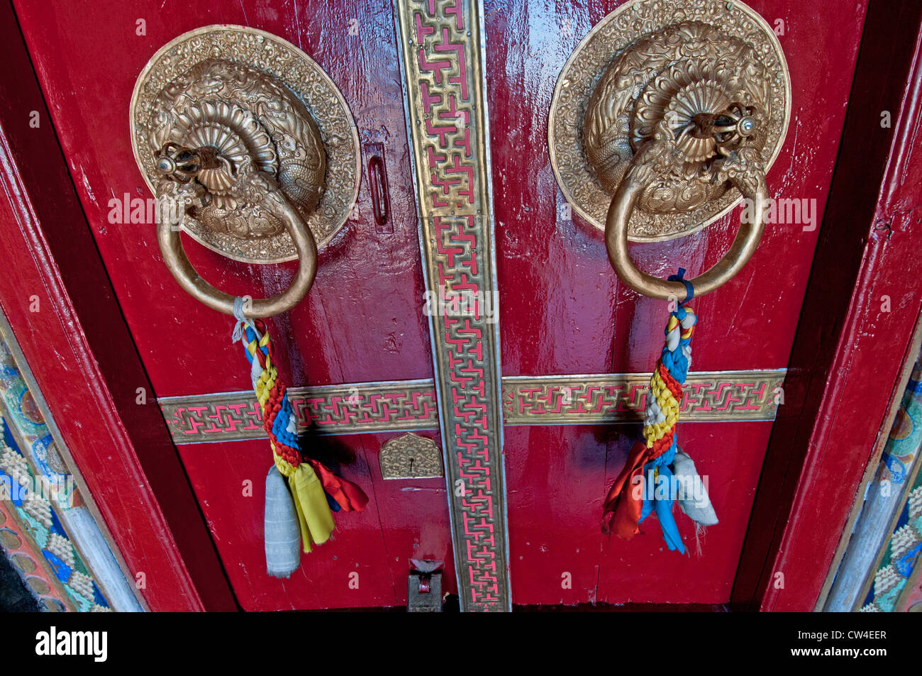 Détail d'un décor traditionnel avec une porte rouge porte laiton d'au monastère Namgyal Tsemo à Leh au Ladakh, Inde Banque D'Images
