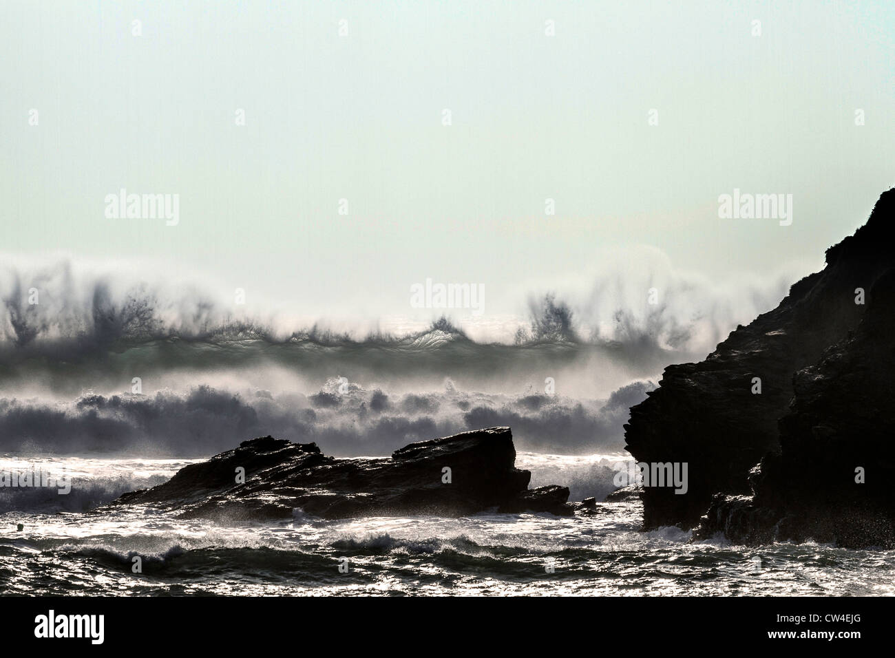 Un fort vent d'ouest apporte une rupture et mers sea mist à Poldhu Cove. Banque D'Images