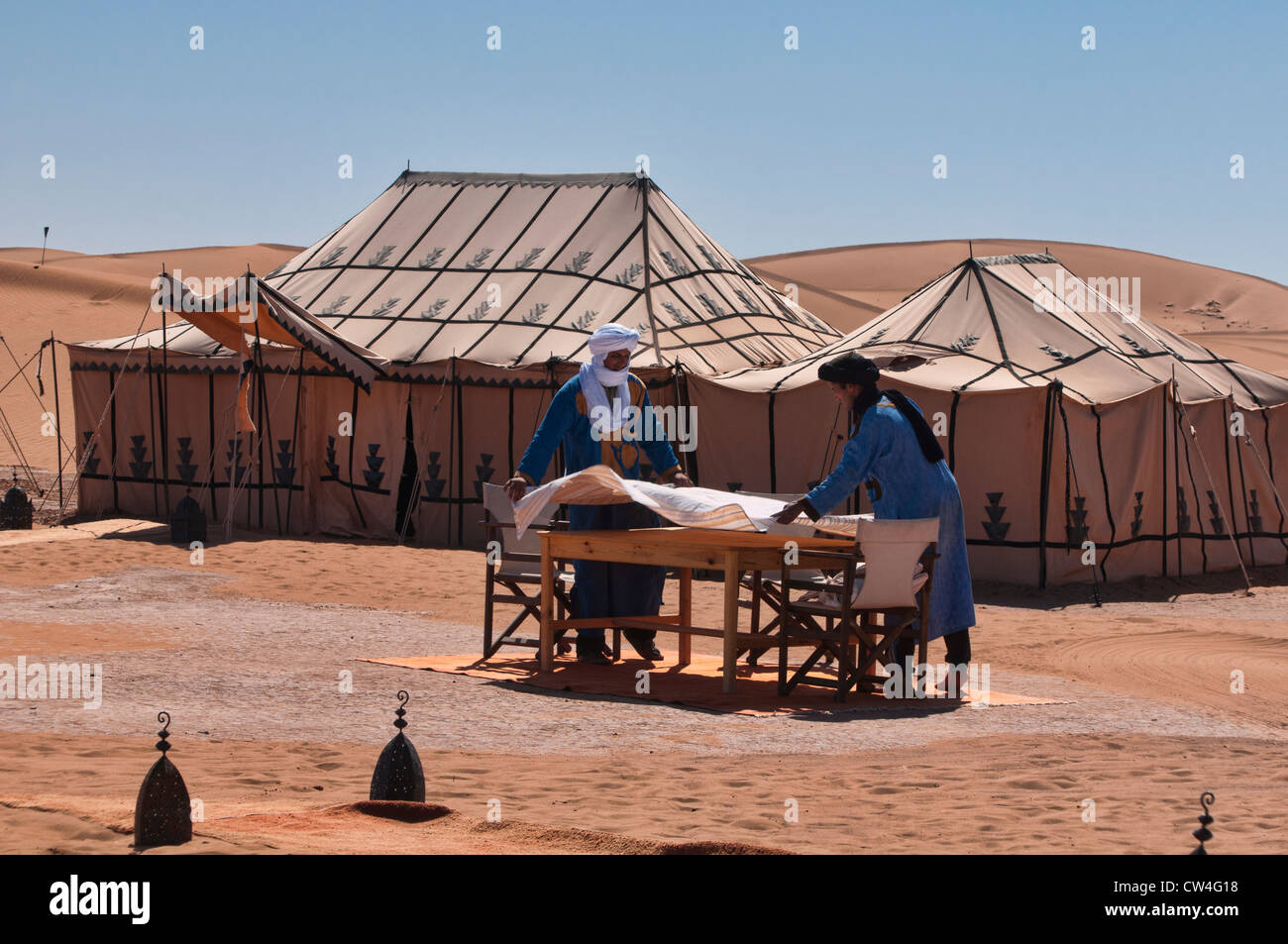 Berbères mis la table dans un luxueux camp dans le désert du Sahara de l'Erg Chigaga, Maroc Banque D'Images