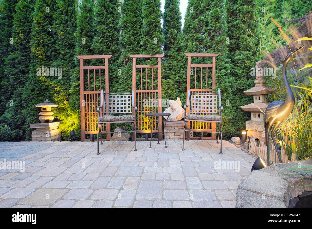 Jardin patio pavé avec Trellis la lanterne de pierre japonais et la Pagode de la grue Bronze Sculpture Banque D'Images