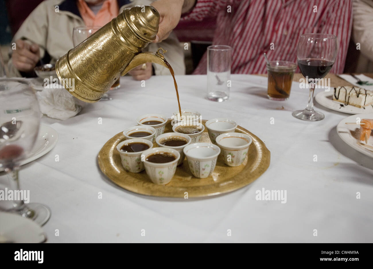 Une cafetière de style turc laiton pouring coffee en tasses après un repas moyen-orientale à Abu Gosh, Israël Banque D'Images