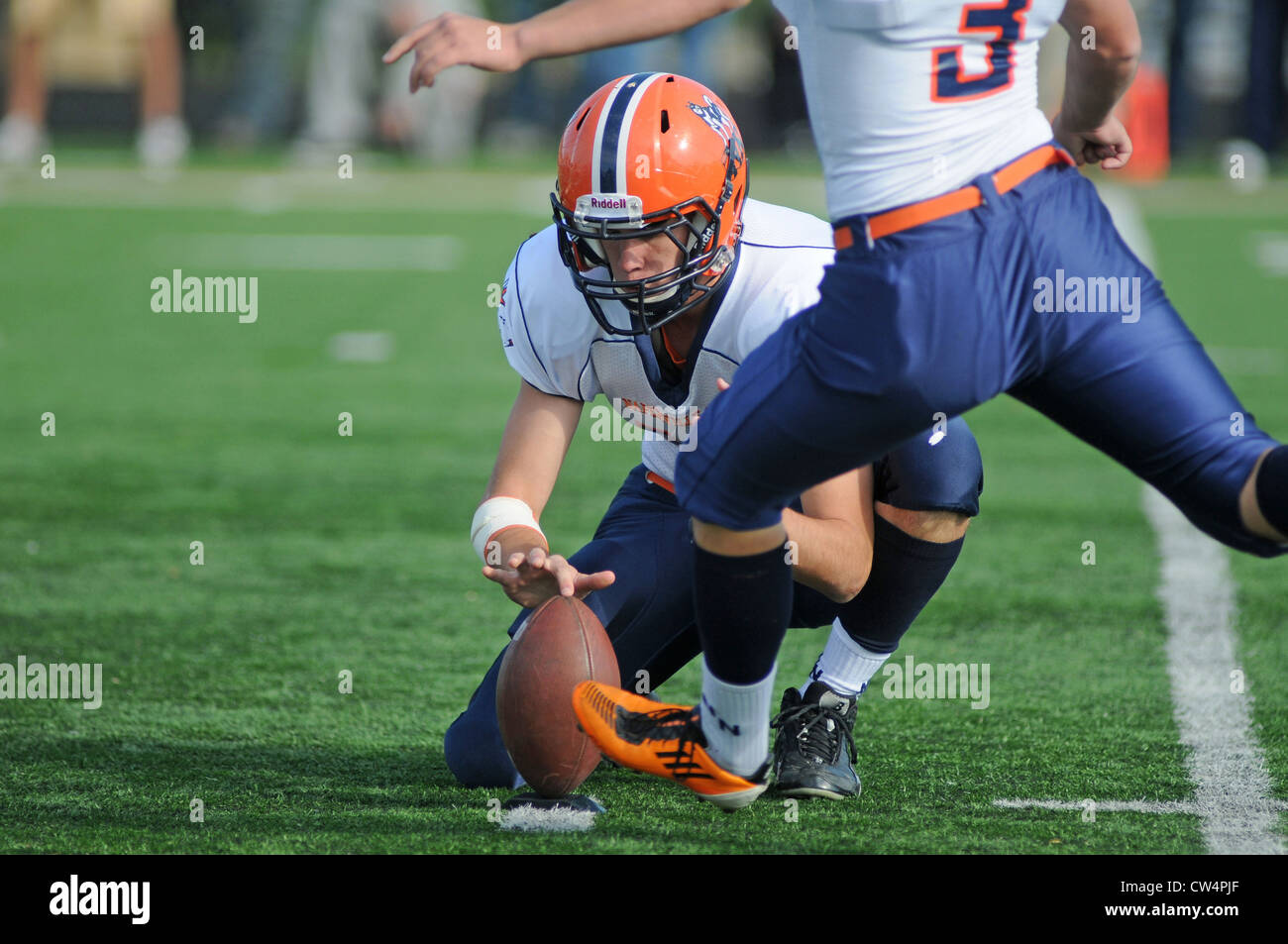 Foot Ball porteur obtient vers le bas en position pour l'effort que l'objectif de champ lecteurs kicker de l'avant au cours des études secondaires en match de football. USA. Banque D'Images