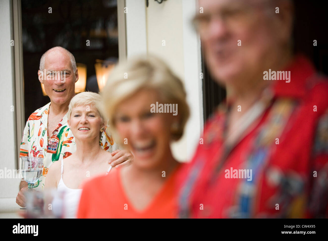 Cheerful senior personnes debout à l'extérieur de maison et holding wineglass Banque D'Images