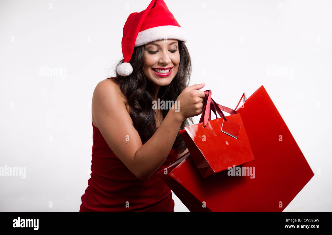 Belle brune portant un chapeau de Noël et des sacs Banque D'Images