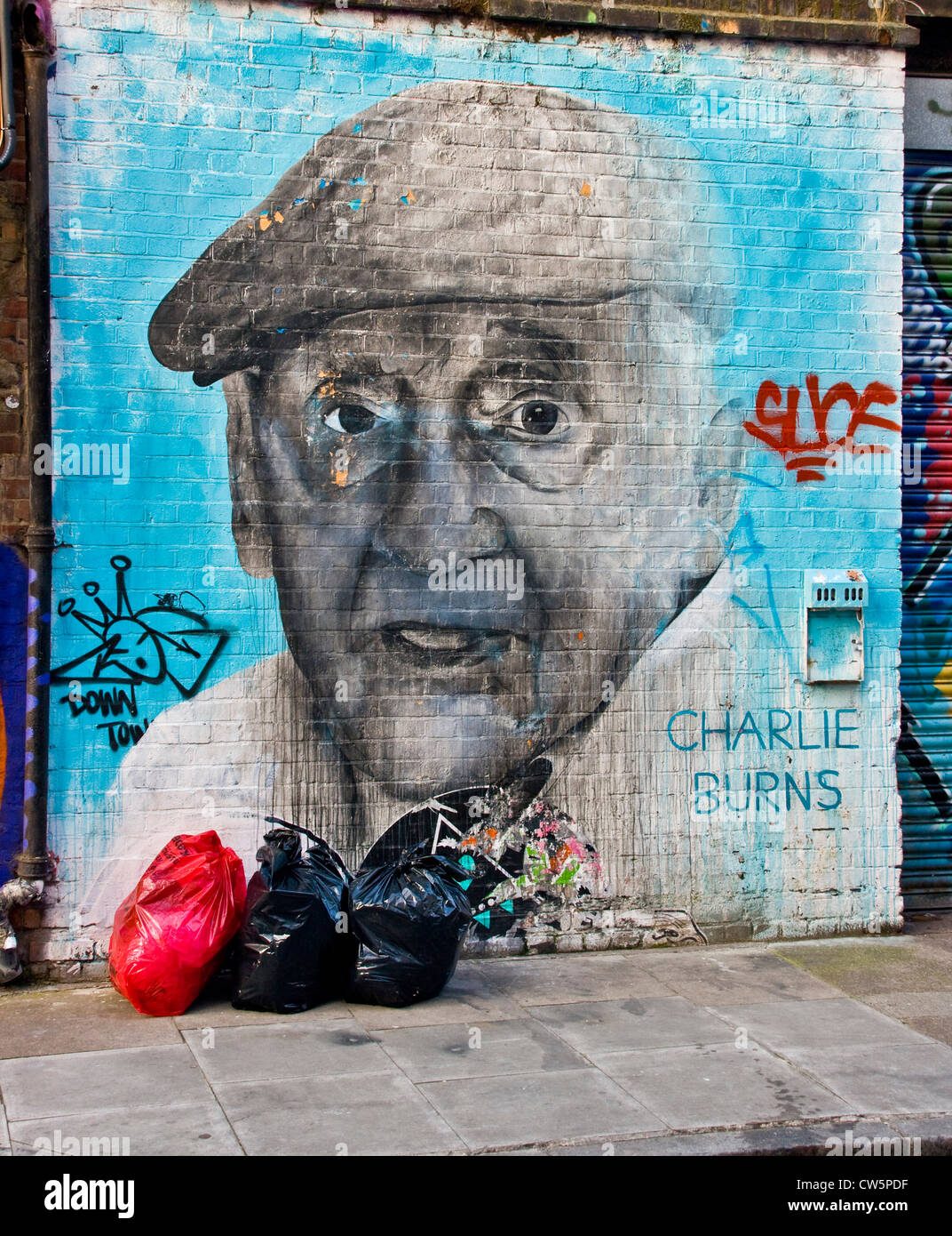 Portrait du célèbre résident Charlie Burns est de Londres par l'artiste de rue Ben lent sur un mur de brique dans le bacon Street London England Banque D'Images