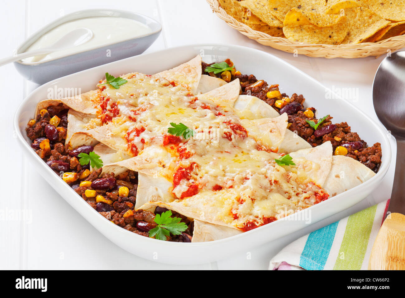 Boeuf enchiladas mexicaines et de maïs avec de la crème sure et les croustilles de maïs. Banque D'Images