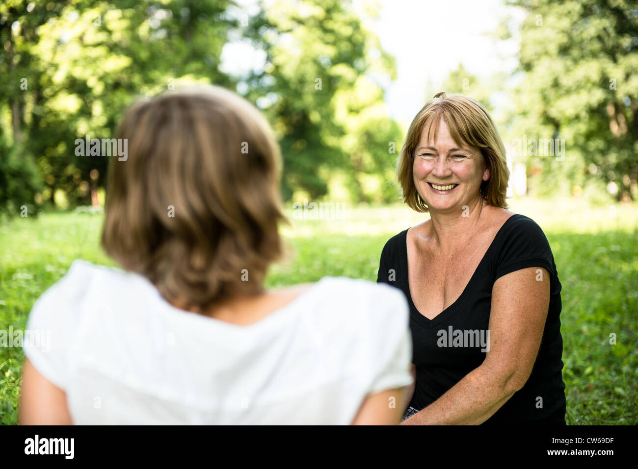 Senior woman chatting avec sa fille adulte dans la nature en plein air Banque D'Images