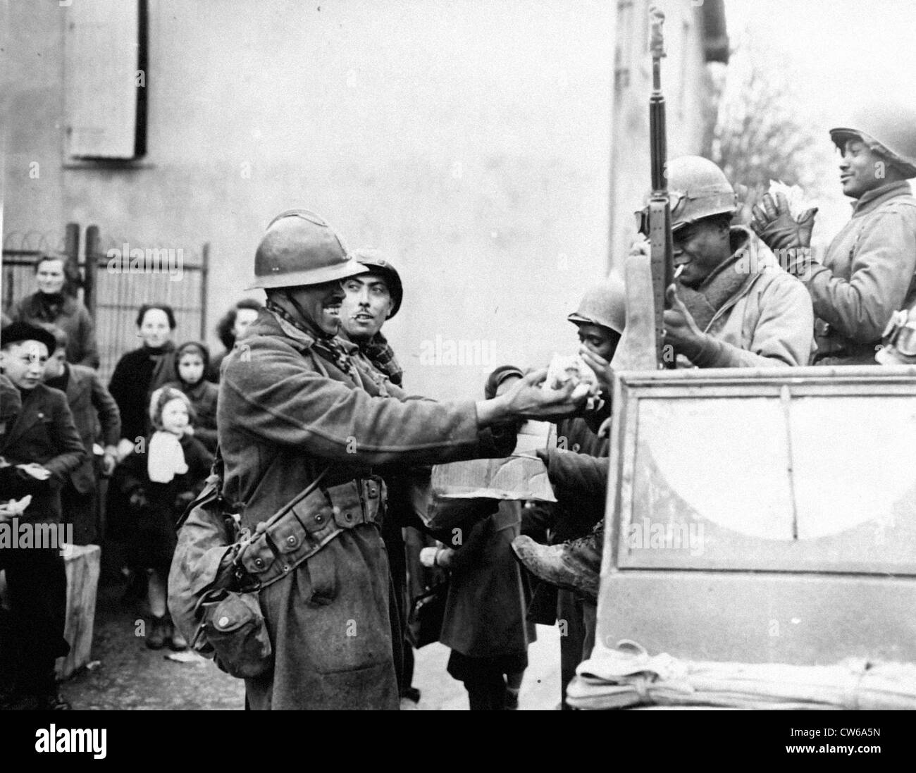 Soldats français agiter candy avec U.S troopers (Rouffach-France-Feb.5,1945) Banque D'Images