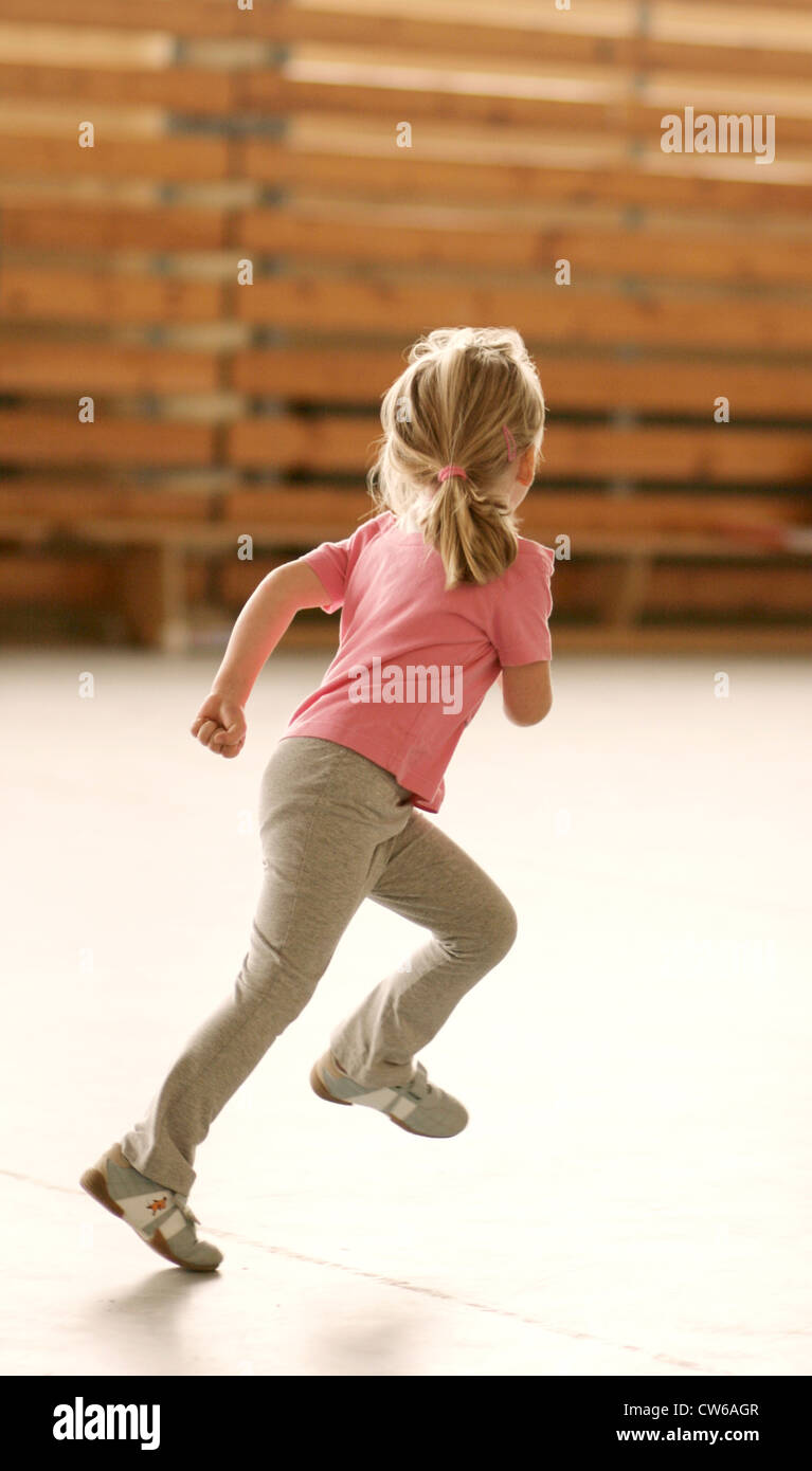 Petite fille courir en salle de sport Banque D'Images