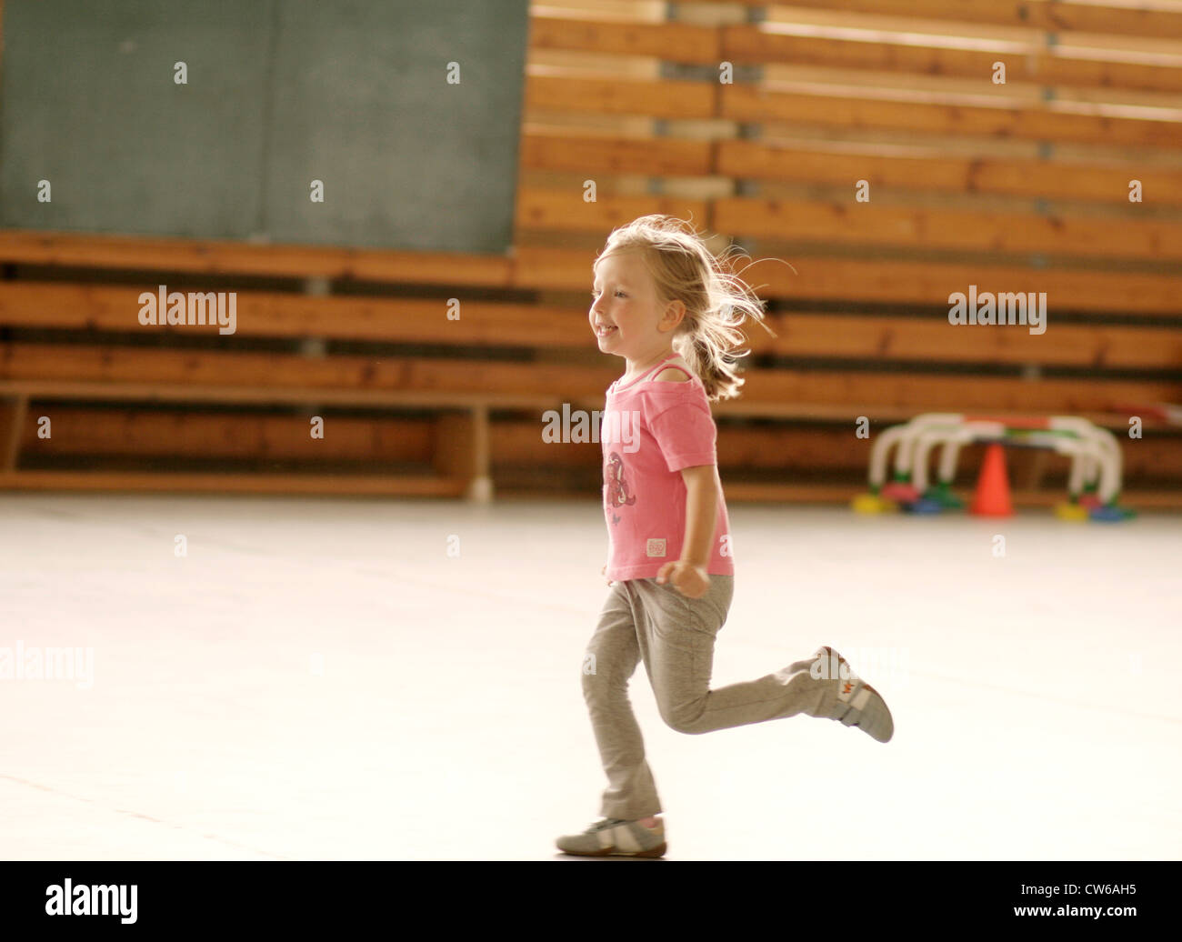 Petite fille courir en salle de sport Banque D'Images