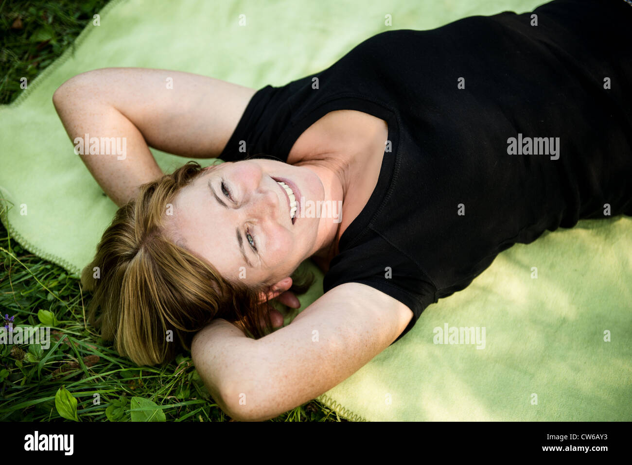Smiling attractive woman outdoor le tapis dans la nature Banque D'Images