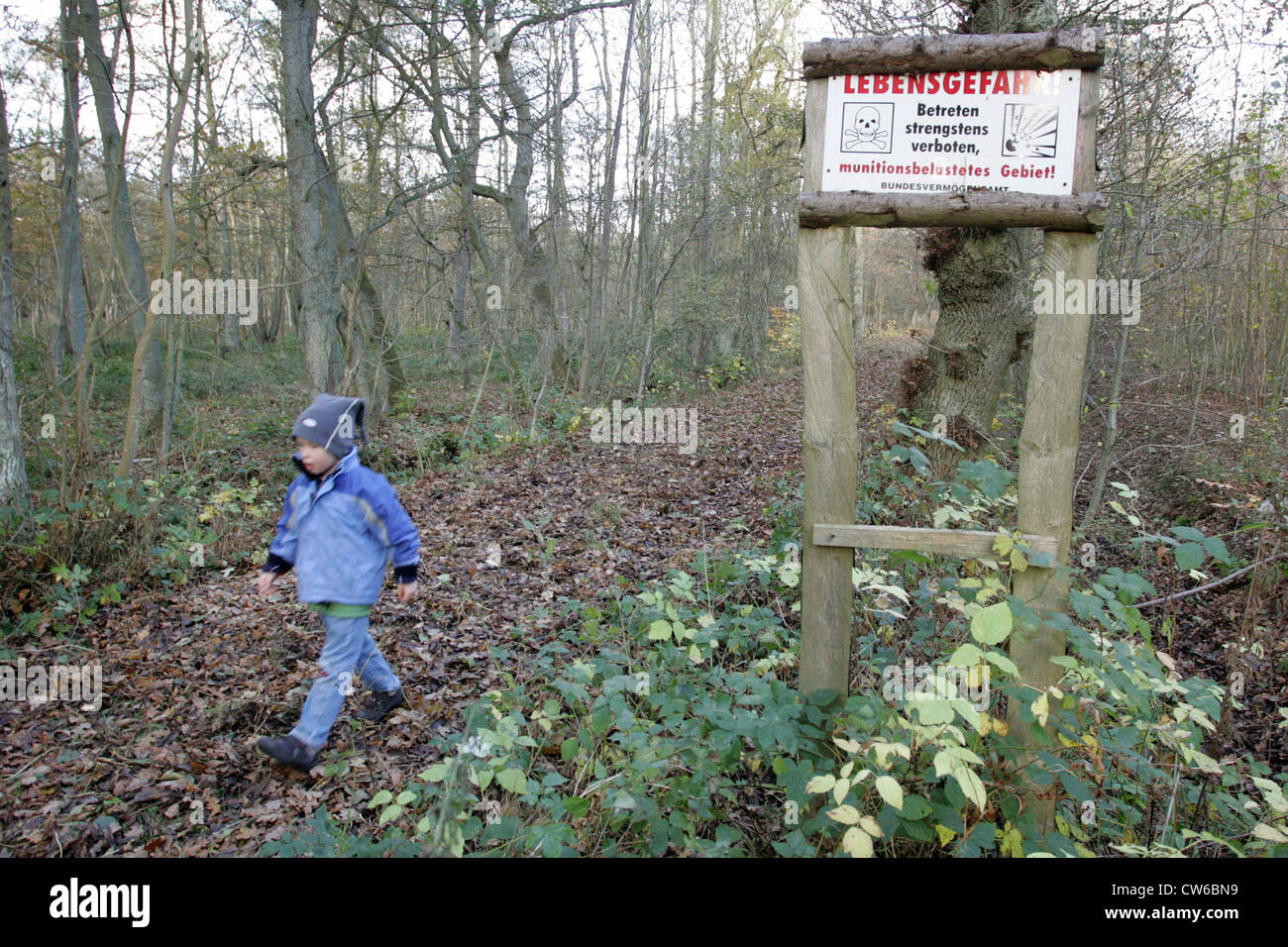 Zingst, un enfant s'exécute sur un sentier forestier avec le signe de danger Banque D'Images