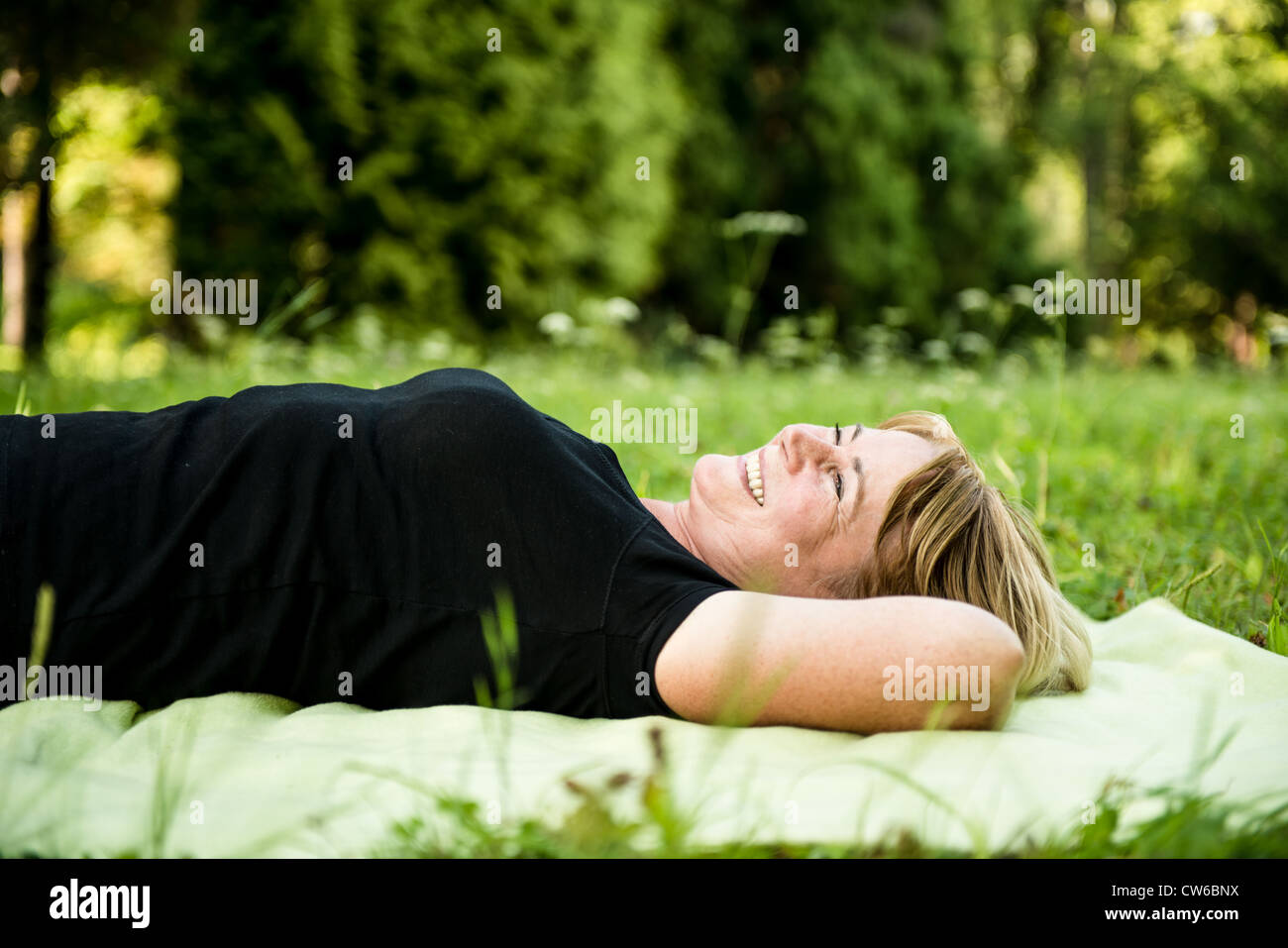 Smiling attractive woman outdoor le tapis dans la nature Banque D'Images