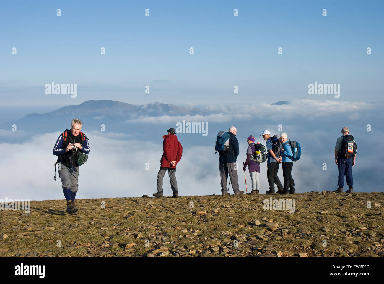 Groupe de marcheurs sur le sommet de Crag Hill, Lake District, en regardant les nuages. Banque D'Images