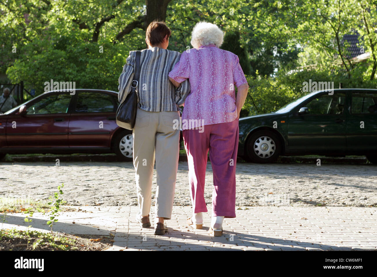 Berlin, une femme contribue à un retraité de l'autre côté de la route Banque D'Images