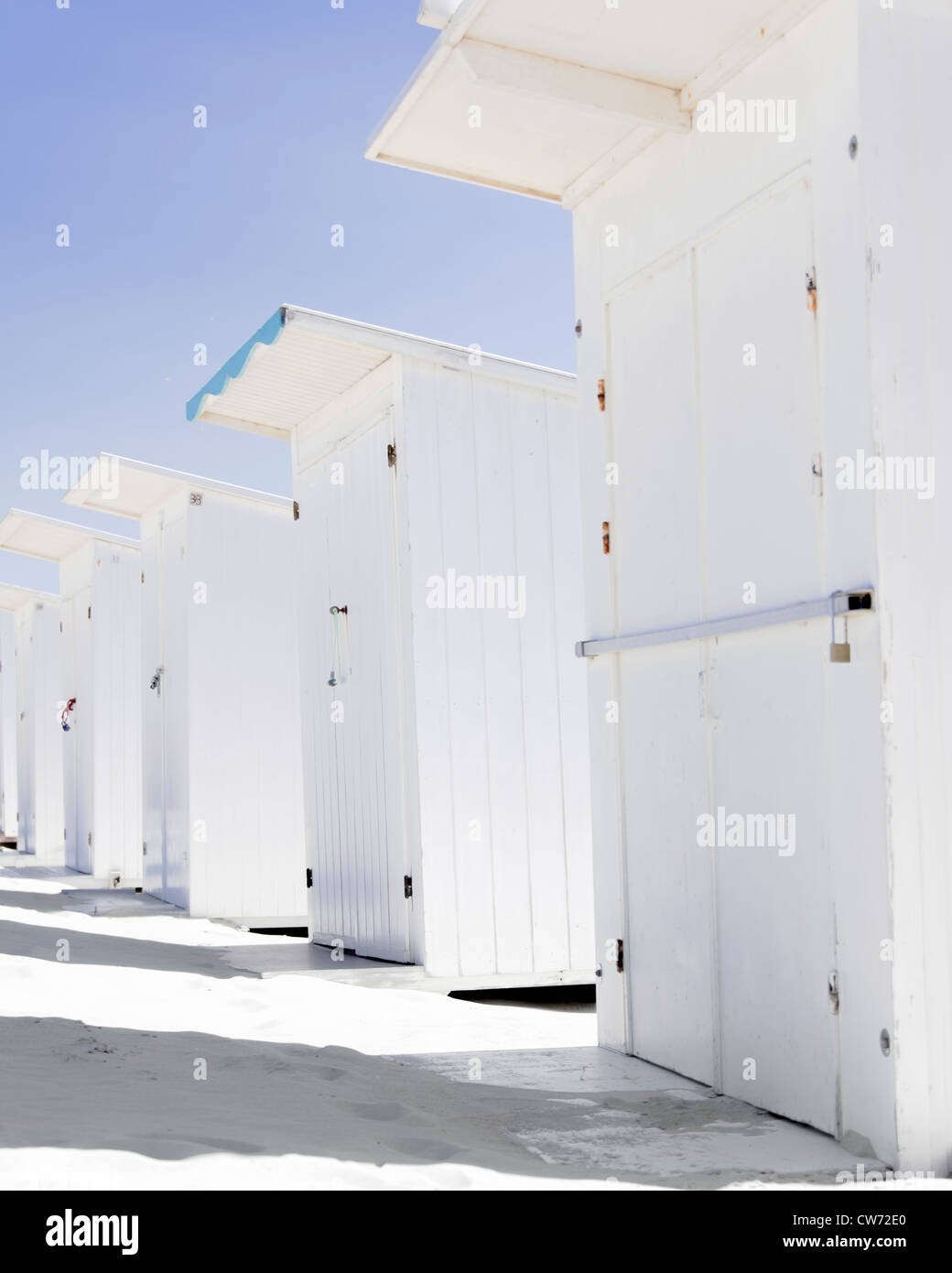 Rangée de cabines de plage blanc sur une plage de sable blanc hêtre contre un ciel bleu profond Banque D'Images