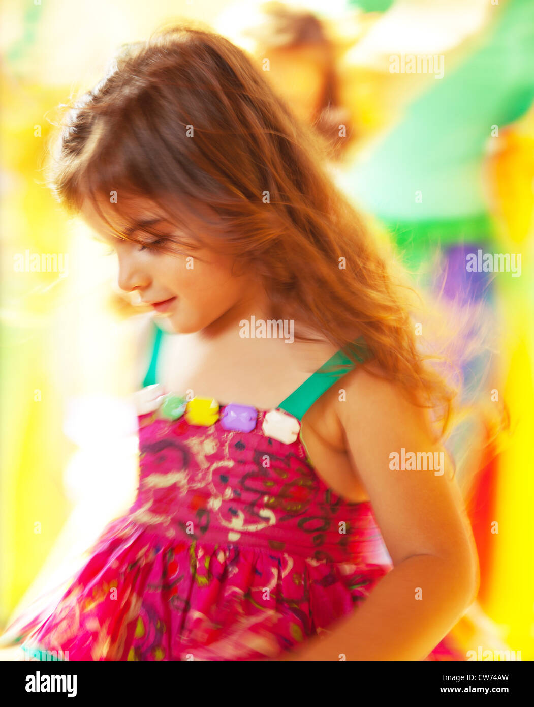 Belle petite fille dansant sur fond coloré, trois ans, fille d'anniversaire, fête d'enfants à l'extérieur, assez heureux enfant jouant Banque D'Images