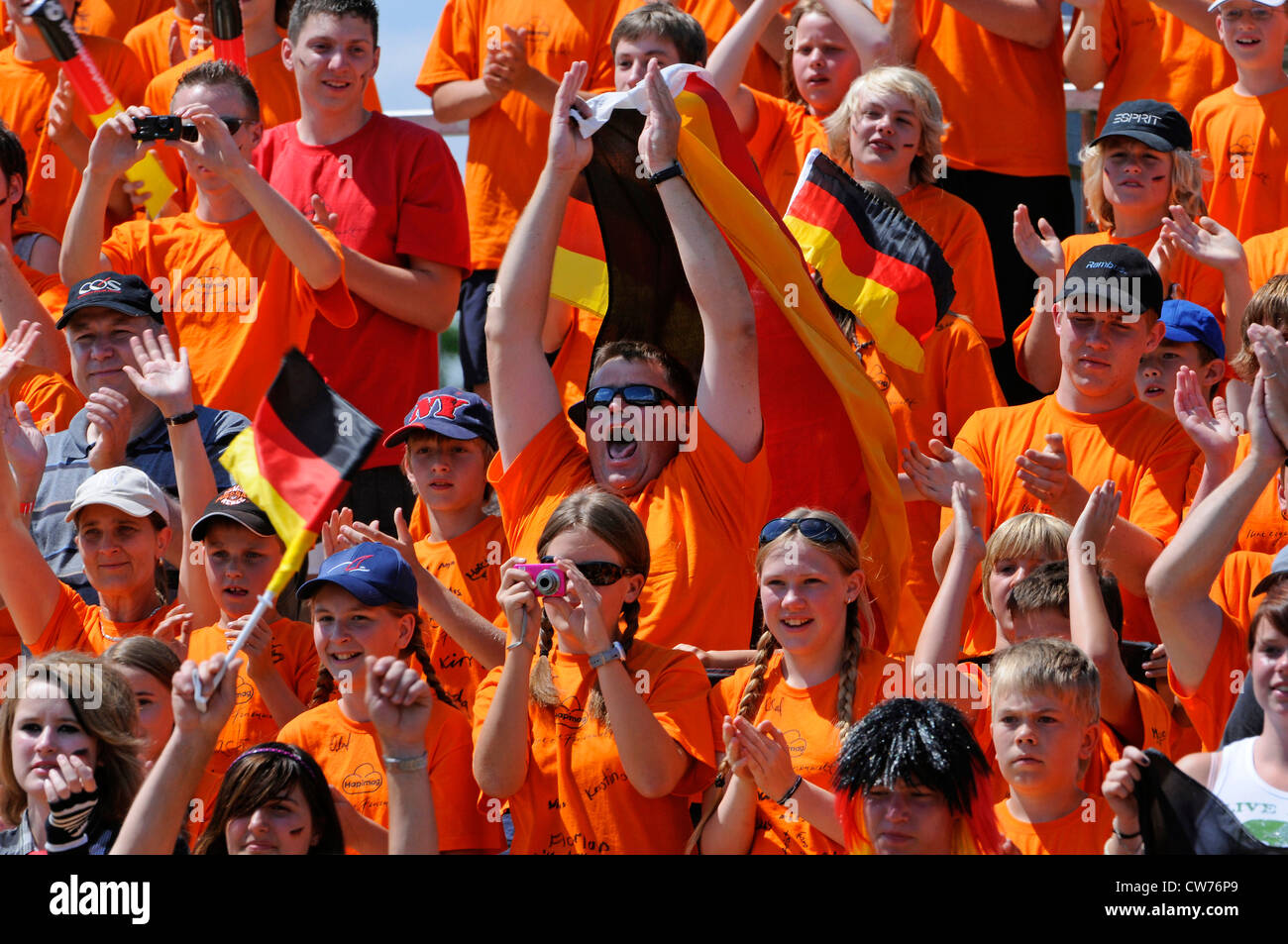 Fans en orange avec drapeau allemand Banque D'Images