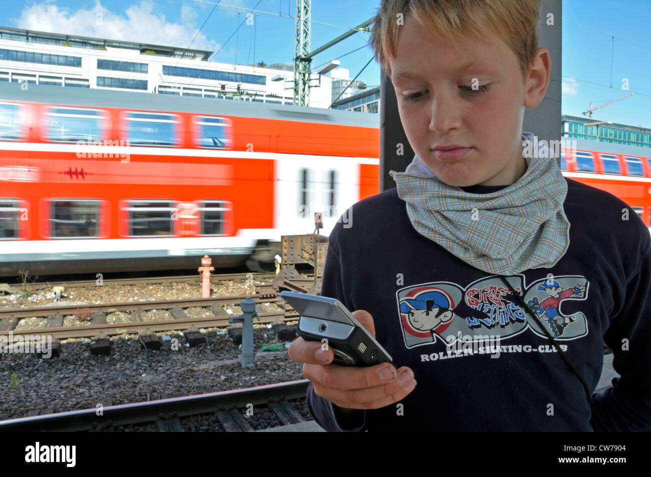 Garçon jouant avec un téléphone mobile à la gare centrale de Stuttgart, Allemagne, Bade-Wurtemberg, Stuttgart Banque D'Images