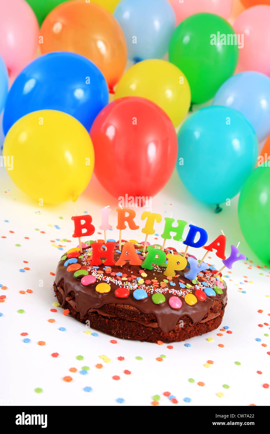 Joyeux anniversaire gâteau au chocolat avec des bougies et des ballons Banque D'Images