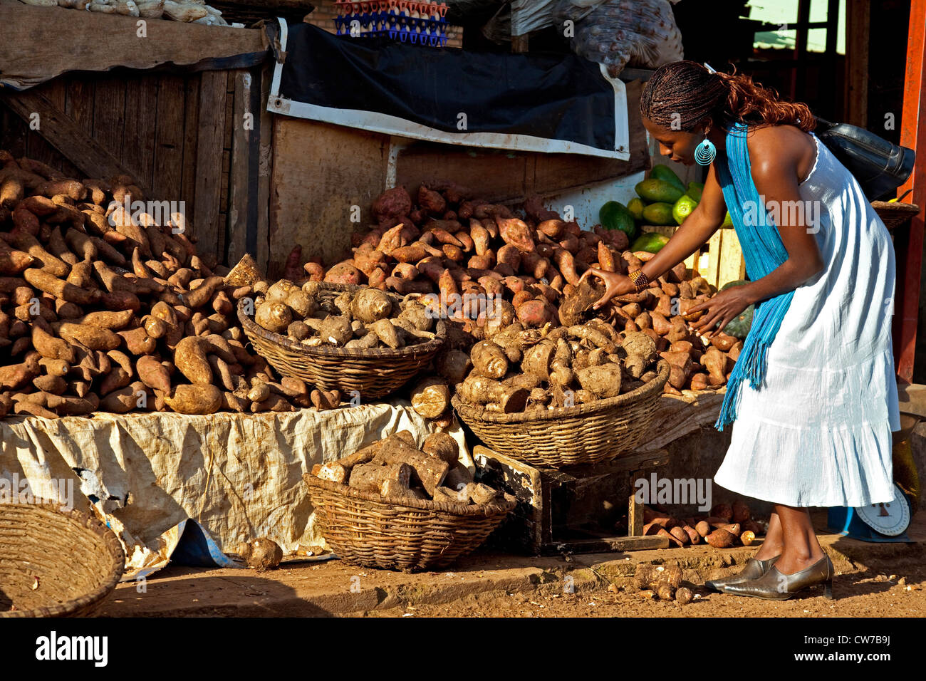 Jeune femme la sélection de meilleurs fruits au stand du marché avec des pommes de terre et l'igname, du Rwanda, de Nyamirambo, à Kigali Banque D'Images