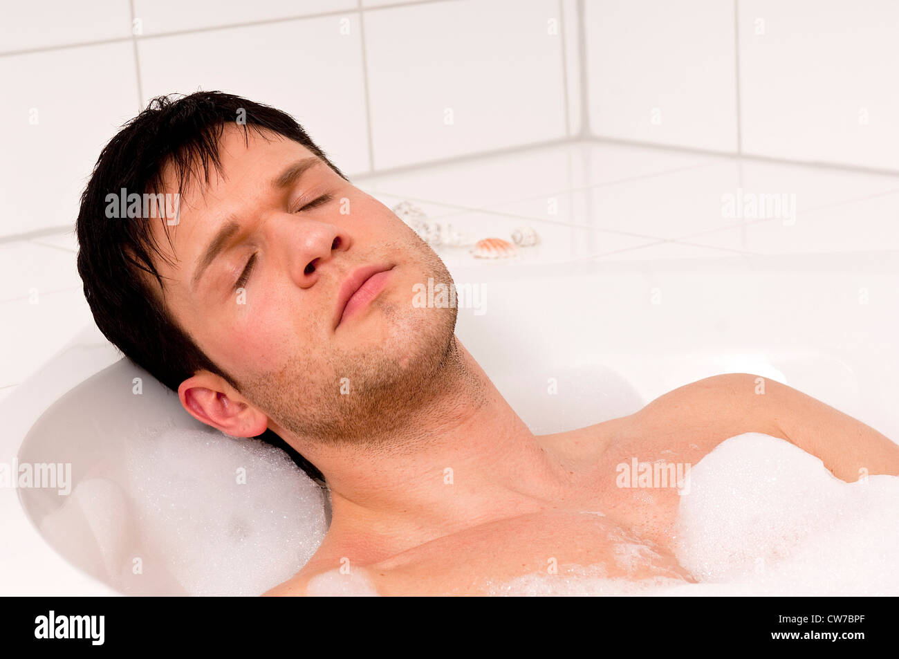 Beau jeune homme de vous détendre dans une baignoire Banque D'Images