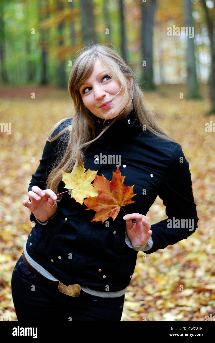 Belle jeune fille en forêt, avec des feuilles en avant de son corps Banque D'Images