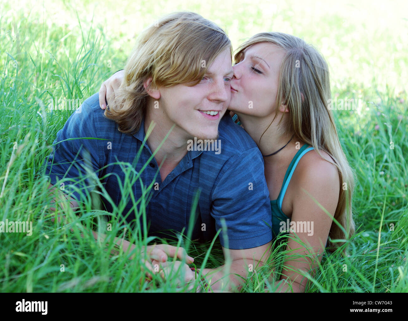 Jeune couple amoureux allongé sur un pré, woman kissing man Banque D'Images