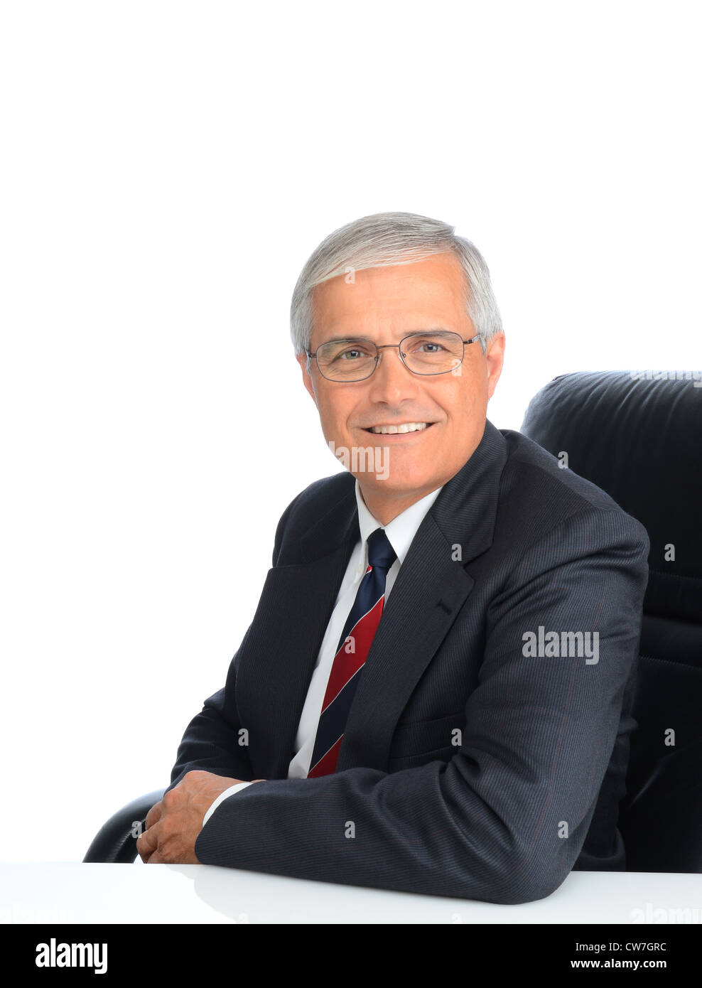 Portrait d'un homme d'âge mûr assis. L'homme est souriant et portant des lunettes, sur un fond blanc. Banque D'Images