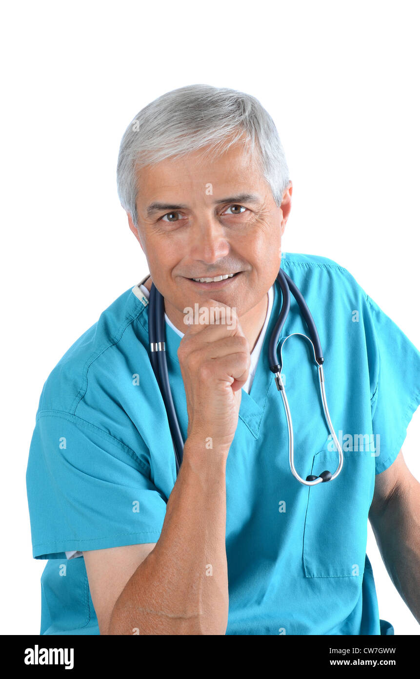 Smiling middle aged médecin avec sa main sur son menton sur un fond blanc. Homme porte un stéthoscope et gommages vert . Banque D'Images