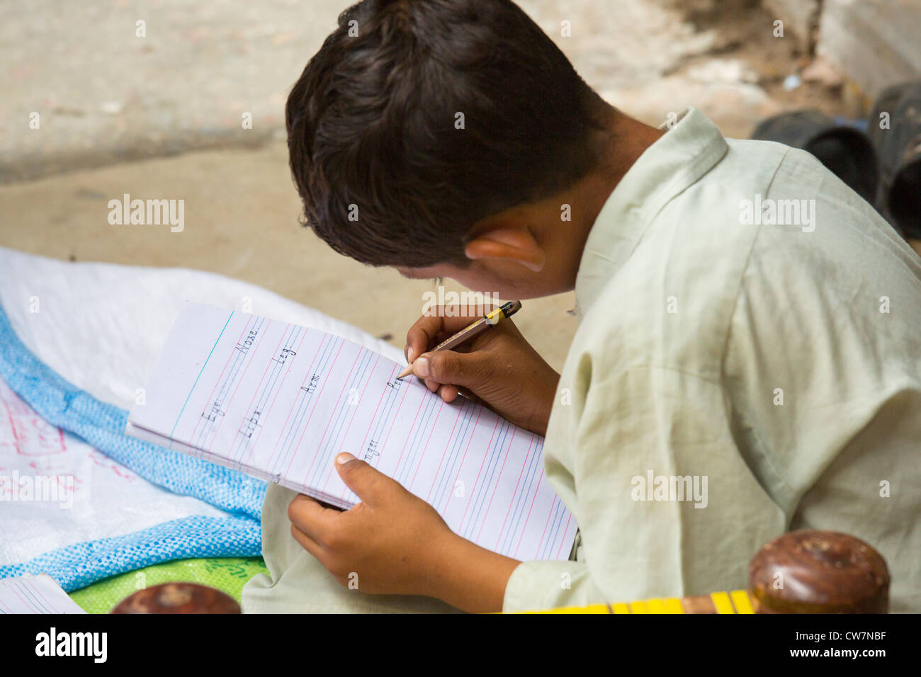 Jeune garçon pakistanais écrit en anglais dit Village Pur, Islamabad, Pakistan Banque D'Images