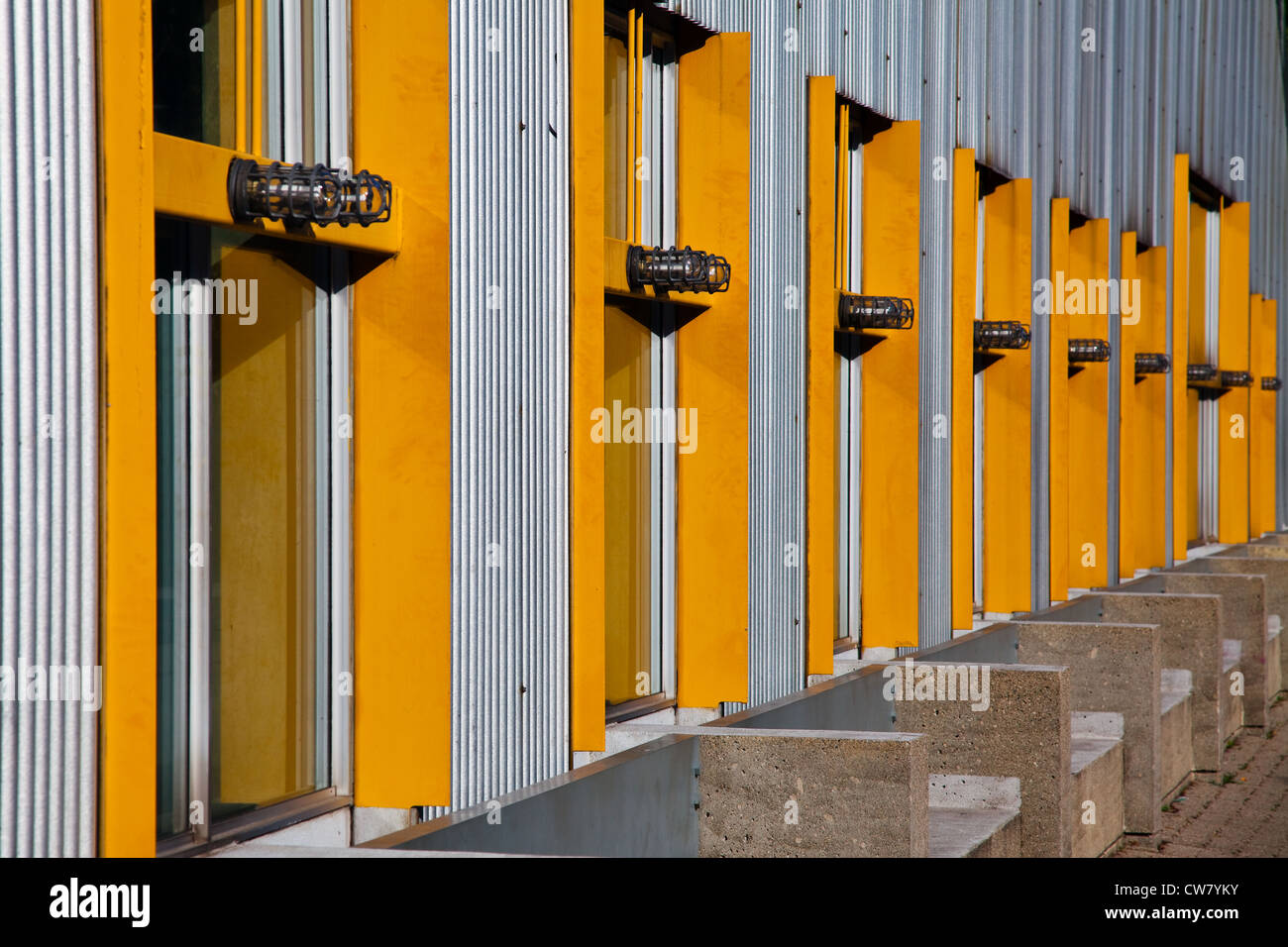 Une rangée de cadres de fenêtre jaune de recul sur un bâtiment avec revêtement métallique, Granville Island, Vancouver, Canada Banque D'Images