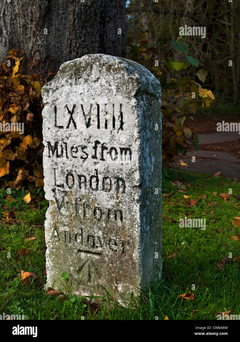Old weathered stone marker jalon sur Thruxton Village vert gravé avec chiffres romains 69 kilomètres de Londres à 5 miles de Andover Banque D'Images