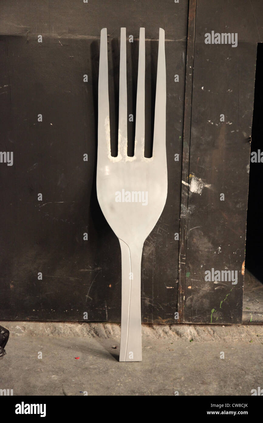 C'est une photo d'un énorme géant qui fourche just stand up le long d'un mur sombre dans un studio. Il doit y avoir quelques accessoires pour un tournage Banque D'Images