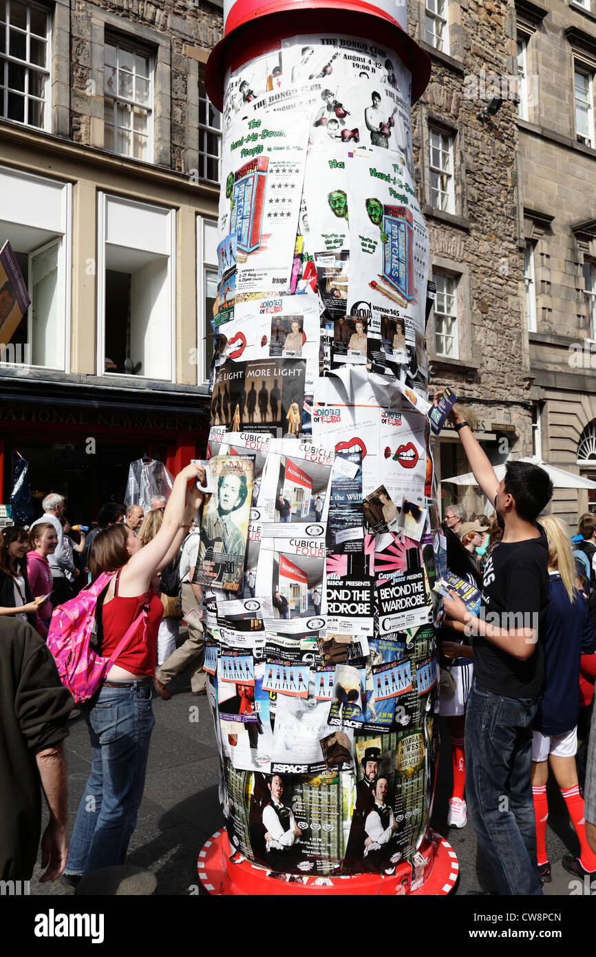 Des gens qui mettent des affiches du Festival Fringe d'Édimbourg sur une tour de publicité, Royal Mile, Écosse, Royaume-Uni Banque D'Images