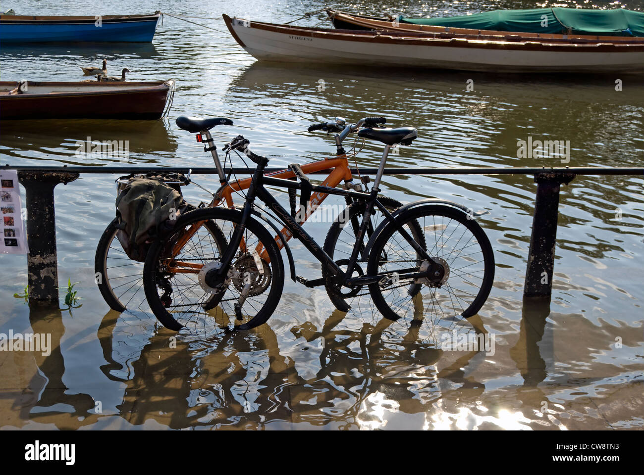 Les vélos verrouillé au garde-corps de la rivière à marée montante, Richmond upon Thames, Surrey, Angleterre Banque D'Images