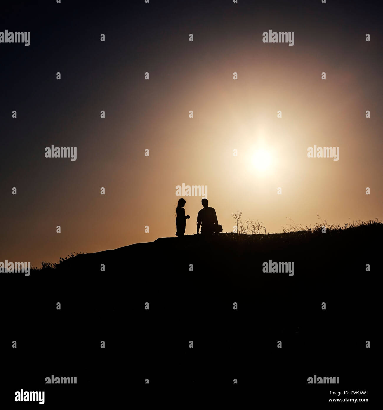 Deux personnes debout dans la lumière arrière sur une colline Banque D'Images