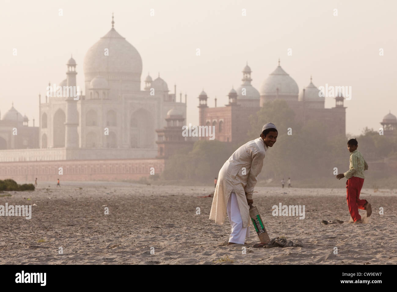 Les garçons à jouer au cricket sur les rives de la rivière Yamuna, avec le Taj Mahal en arrière-plan Banque D'Images