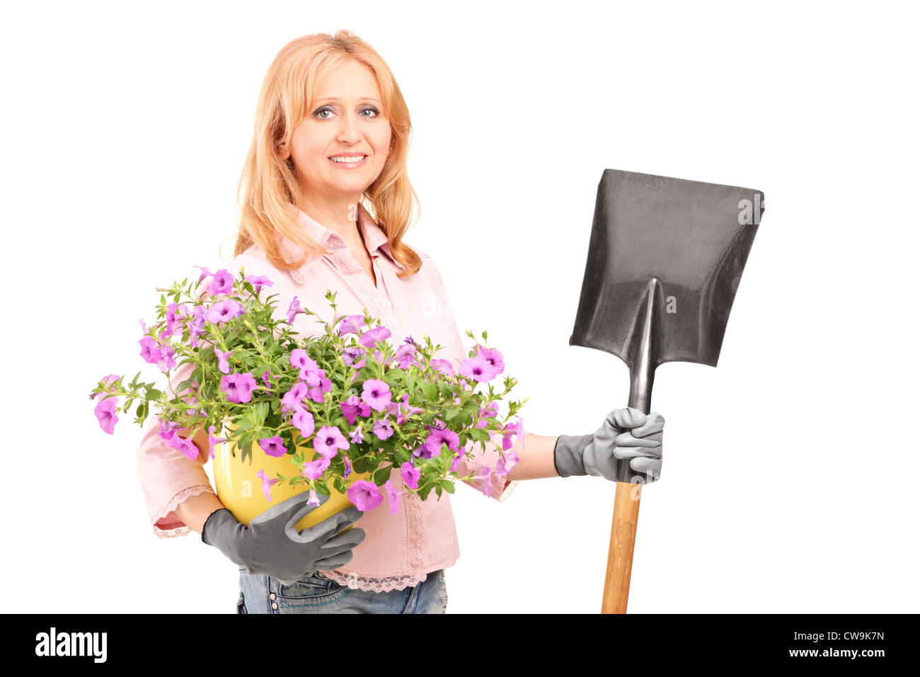 Un jardinier femelle holding Flowers et une pelle isolé sur fond blanc Banque D'Images