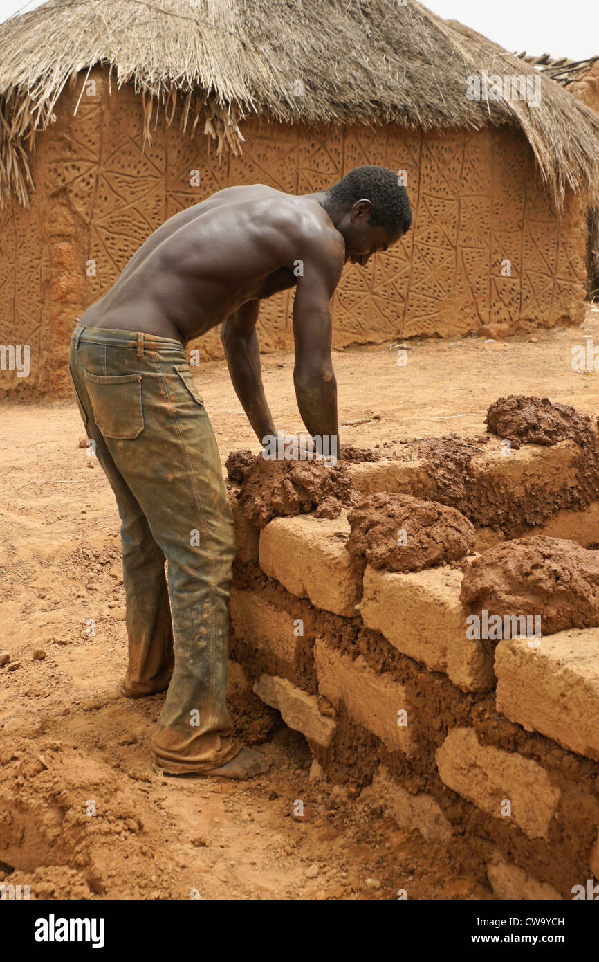 L'homme de boue-brique construction maison à Mognori Eco-Village, Ghana Banque D'Images