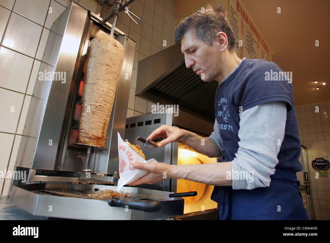Berlin, un vendeur rend la viande dans un sac à sandwich Banque D'Images