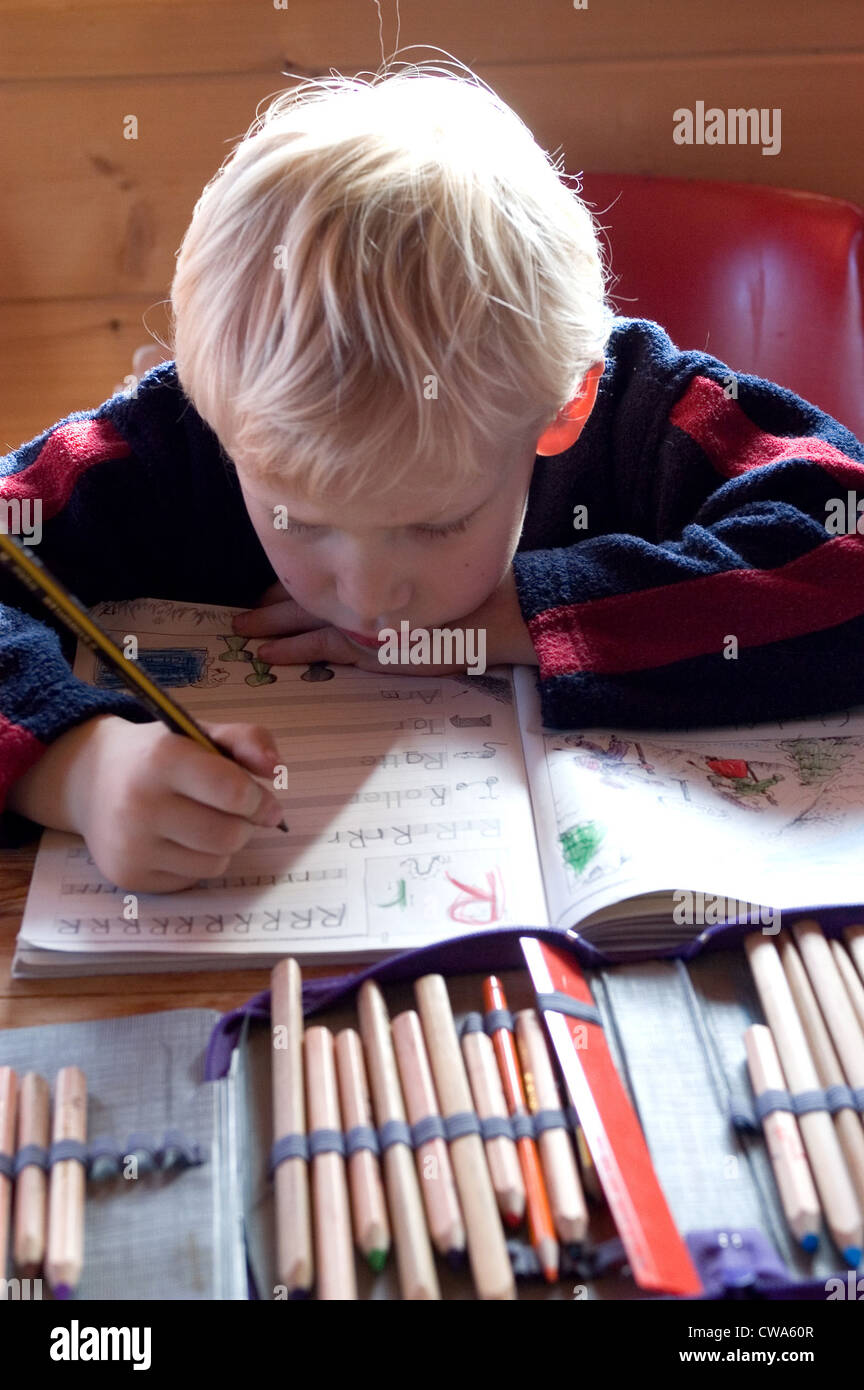 Un garçon fait ses devoirs Banque D'Images